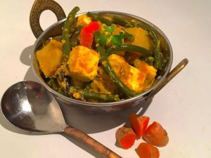 Small bowl of Belicious Paneer Pan Fry Creamy Curry with a serving spoon next to it